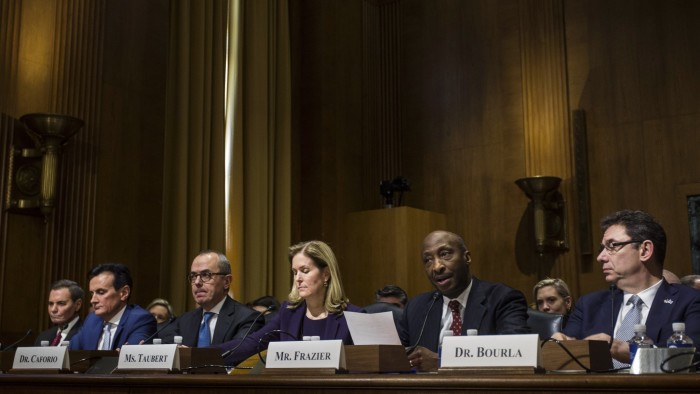 Ken Frazier, chairman and chief executive officer of Merck & Co., second right, testifies during a Senate Finance Committee hearing on drug pricing on Capitol Hill in Washington, D.C., U.S., on Tuesday, Feb. 26, 2019. Top executives from seven of the world's biggest drug companies are testifying before Congress to talk about drug costs, a long-awaited session that could kickstart legislation to rein in prices. Photographer: Zach Gibson/Bloomberg