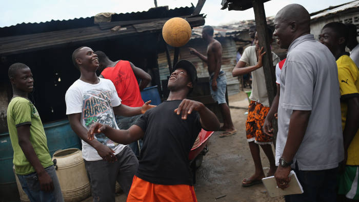 MONROVIA, LIBERIA - AUGUST 15: Young men show off their ball handling skills in the West Point slum on August 15, 2014 in Monrovia, Liberia. Poor sanitation and close quarters have contributed to the spead of the Ebola virus, which is transmitted through bodily fluids. The epidemic has killed more than 1,000 people in four West African countries. (Photo by John Moore/Getty Images)