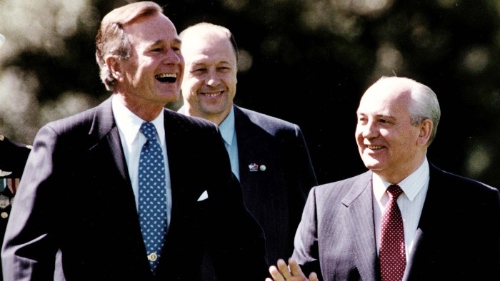 This photo shows former US President George Bush(L) as he smiles with former Soviet President Mikhail Gorbachev(R) on the South Lawn of the White House 31 May 1990,in Washington,DC, after reviewing US military units at a formal summit arrival ceremony. They are accompanied by a translator(C). AFP PHOTO/Tim CLARY / AFP / TIMOTHY A. CLARY (Photo credit should read TIMOTHY A. CLARY/AFP/Getty Images)