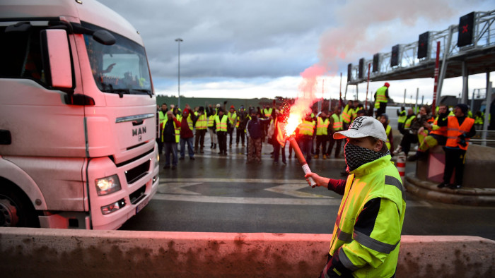 TOPSHOT - &quot;Yellow Vest&quot; (Gilets Jaunes) protesters take part in a free-passage operation at the toll collection area on the A31 motorway in Beaumont, eastern France, on November 24, 2018, during a demonstration to protest against high fuel prices and living costs. - Police fired tear gas and water cannon Saturday in central Paris against &quot;yellow vest&quot; protesters demanding French President Emmanuel Macron roll back tax hikes on motor fuel. (Photo by JEAN-CHRISTOPHE VERHAEGEN / AFP)JEAN-CHRISTOPHE VERHAEGEN/AFP/Getty Images