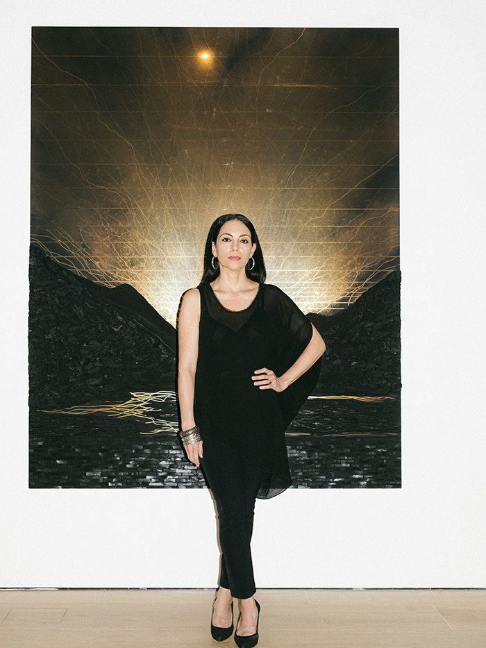 Teresita Fernández photographed for The FT, at Lehmann Maupin Gallery, New York. In front of her artwork: Dark Earth (Glory), 2019. Solid charcoal and mixed media on chromed panel, 80 x 64 x 2 inches (203.2 x 162.6 x 5.1 cm)