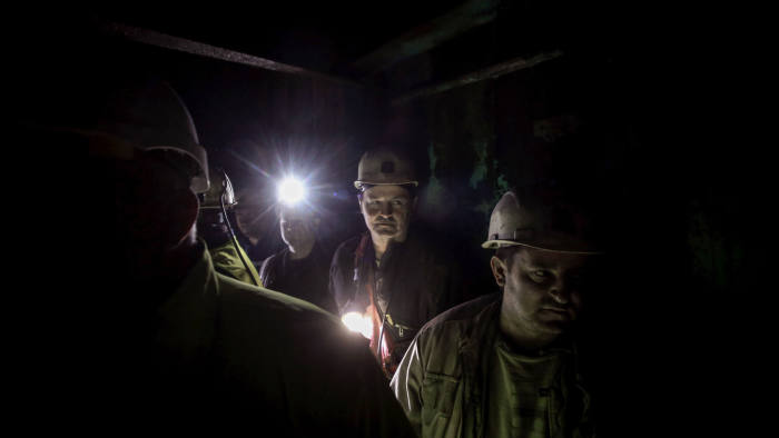 Miners use the elevator on their way to a coffee break at "The Pit" (Jama in Serbian) cafe, some 420 meters below the surface in Bor, eastern Serbia on December 1, 2018. - Four hundred metres (1,300 feet) below the small city of Bor, the depth of Serbia's love for coffee is on display as men in hard-hats huddle inside a cafe carved into the walls of their copper mine. Known as "The Pit", the cave-like room has rough earthen walls and long wooden tables where miners and visitors can sip hot drinks and smoke cigarettes in the centre of RTB Bor, the biggest copper mine in Serbia. (Photo by OLIVER BUNIC / AFP) (Photo credit should read OLIVER BUNIC/AFP via Getty Images)