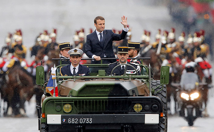 Newly elected French president Emmanuel Macron waves as he parades in a military car on the Champs Elysees avenue, after his formal inauguration ceremony, on May 14, 2017 in Paris. / AFP PHOTO / POOL / Michel Euler (Photo credit should read MICHEL EULER/AFP/Getty Images)