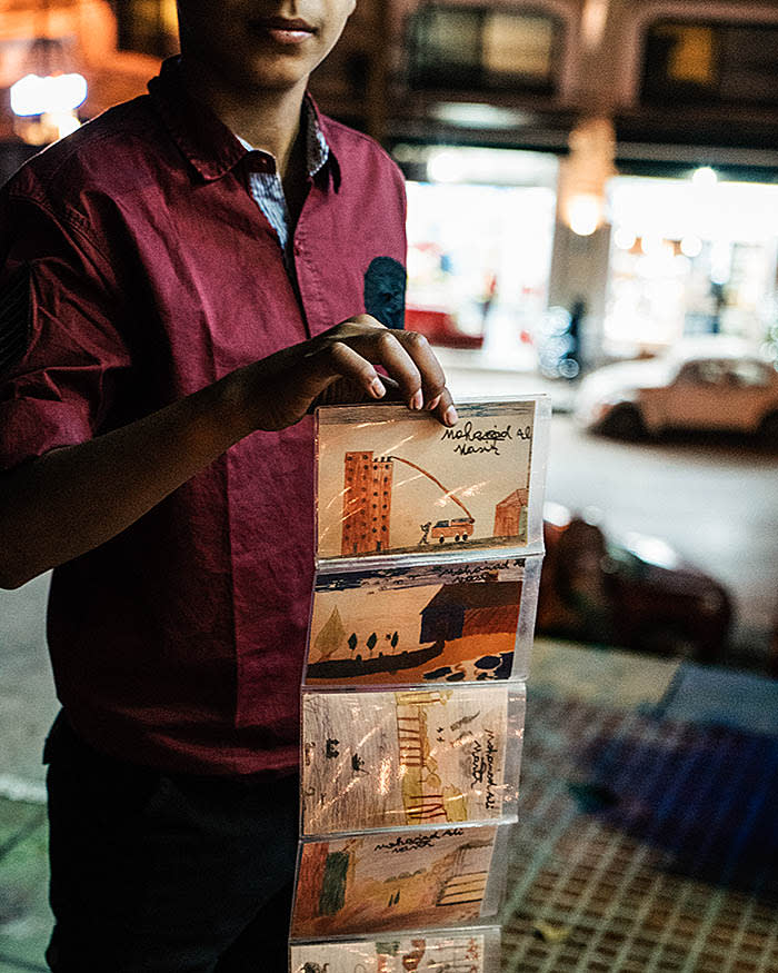 Beirut, Lebanon - December 28, 2017: A street kid shows an envelope with the postcards that he sells on the street. The postcards are drawings from other street kids. The young vendor told us that he would like, one day, to be able to open an art gallery where he can sell his art. Street kids in Beirut sells roses or little merchandise to bar goers. Most of these kids endured war and starvation in Syria before traveling with their families to Lebanon.