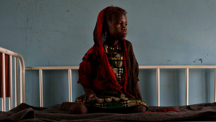 A young girl who is sick sits on a bed in teh children's ward in the health clinic in  Baga Sola, Chad Tuesday, Oct. 4, 2016. 