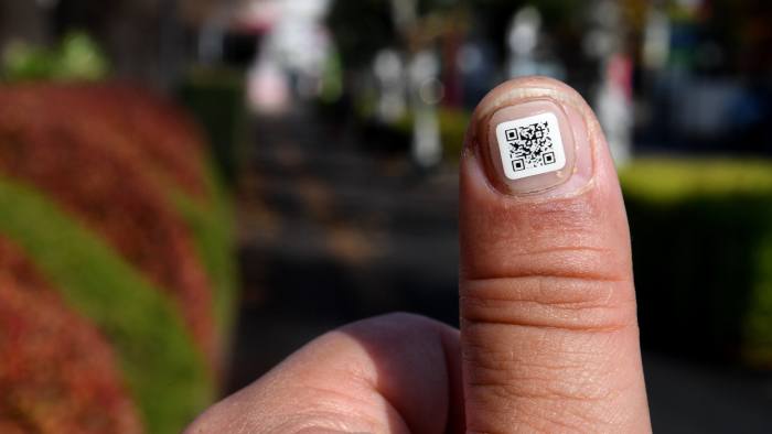 This picture taken on December 5, 2016 shows a city officer displaying a QR code on his fingernail near the Iruma city hall in Iruma, Saitama prefecture, a western suburb of Tokyo. A Japanese city has introduced a novel way to keep track of senior citizens with dementia who are prone to getting lost -- tagging their fingers and toes with scan-able barcodes. A company in Iruma, north of Tokyo, developed tiny nail stickers, each of which carries a unique identity number to help concerned families find missing loved ones, according to the city's social welfare office / AFP / Toshifumi KITAMURA (Photo credit should read TOSHIFUMI KITAMURA/AFP/Getty Images)