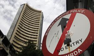 The Bombay Stock Exchange (BSE) building looms over a no-entry sign on a street in Mumbai, India, on Monday, Aug. 19, 2013. IndiaÕs biggest stock market slide in almost two years, surging bond yields and an unprecedented plunge in the rupee are pressuring officials for fresh steps to stem capital outflows and revive a struggling economy. Photographer: Prashanth Vishwanathan/Bloomberg