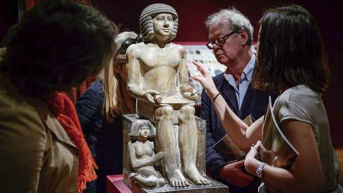 Members of the public and gallery staff examine The Northampton Sekhemka, an Egyptian painted limestone statue of Sekhemka, Inspector of the Scribes, at Christie's auction house in central London on June 13, 2014. The statue is going to auction on July 10, 2014 with an expected reserve of 4-6 million GPD (5-7 million Euros, 7-10 million USD). AFP PHOTO / LEON NEAL (Photo credit should read LEON NEAL/AFP/Getty Images)