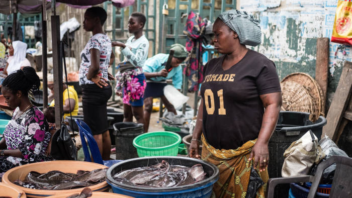 In community of Isale Ijebu in Ajah, Lagos; Tinu mans the front of her market stand where she sells catfish surrounded by other vendors
