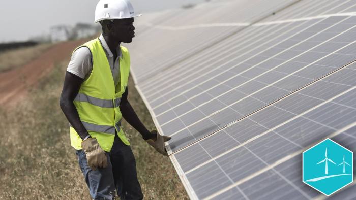 A worker inspects photovoltaic solar panels in an array at the Senergy Santhiou Mekhe PV solar plant in Thies, Senegal, on Monday, Oct. 16, 2017. The electricity produced at the 30 megawatt site, West Africa's largest to date, will be bought by the Senegal National Electricity Company (SENELEC) and injected into the national network. Photographer: Xaume Olleros/Bloomberg