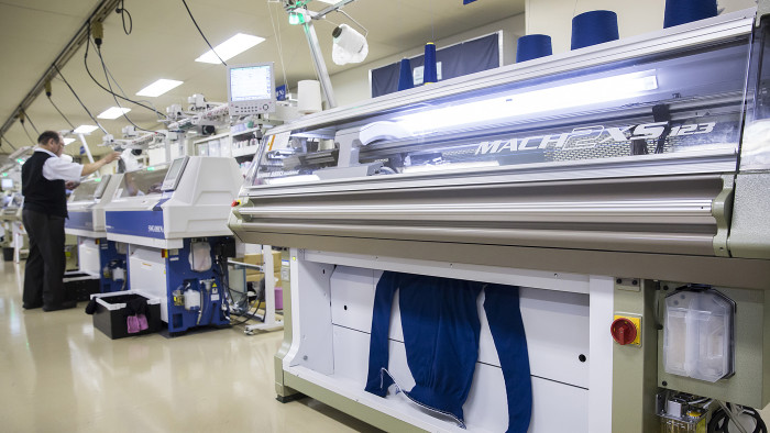 A sweater exits a whole-garment knitting machine inside the design center at the Shima Seiki Manufacturing Ltd. headquarters in Wakayama, Japan, on Tuesday, Sept. 12, 2017. Shima Seiki is one of the top global suppliers of advanced knitting machines, which create seamless and other clothing for brands from Prada and Giorgio Armani to Fast Retailing Co.’s Uniqlo. Photographer: Tomohiro Ohsumi/Bloomberg