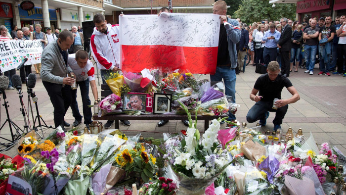 People pay their respects ahead of a minute's silence, at the shopping centre where exactly a week ago Arek Jozwik was killed, in Harlow, Essex, east of London on September 3, 2016. Six local teenagers have been arrested and released on bail pending further investigation following the attack on the 40-year-old factory worker, in a run-down open air shopping centre in the town. / AFP PHOTO / JUSTIN TALLISJUSTIN TALLIS/AFP/Getty Images