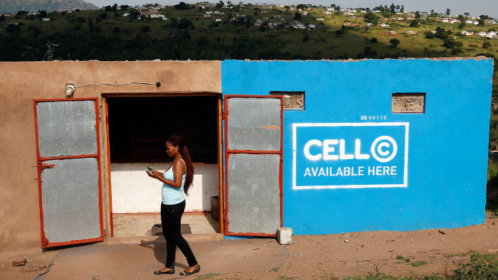 A woman uses her mobile phone in front of a store with telecom company Cell C branding in Kwandengezi, South Africa March 28, 2017. REUTERS/Rogan Ward - RC15FD457D40