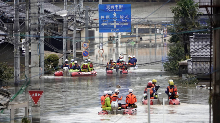Rescuers on boats head for search in the partly submerged area in water after heavy rain in Kurashiki city, Okayama prefecture, southwestern Japan, Sunday, July 8, 2018. Heavy rainfall hammered southern Japan for the third day, prompting new disaster warnings on Kyushu and Shikoku islands Sunday. (Koji Harada/Kyodo News via AP)