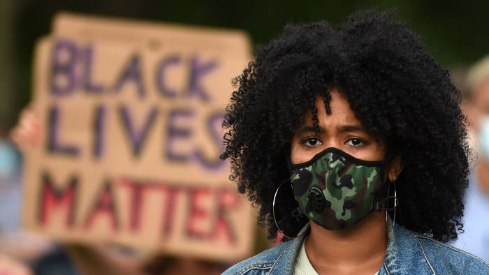 A protester wearing a protective face mask attends a gathering in support of the Black Lives Matter movement on Woodhouse Moor in Leeds in northern England on June 21, 2020, in the aftermath of the death of unarmed black man George Floyd in police custody in the US. (Photo by Oli SCARFF / AFP) (Photo by OLI SCARFF/AFP via Getty Images)
