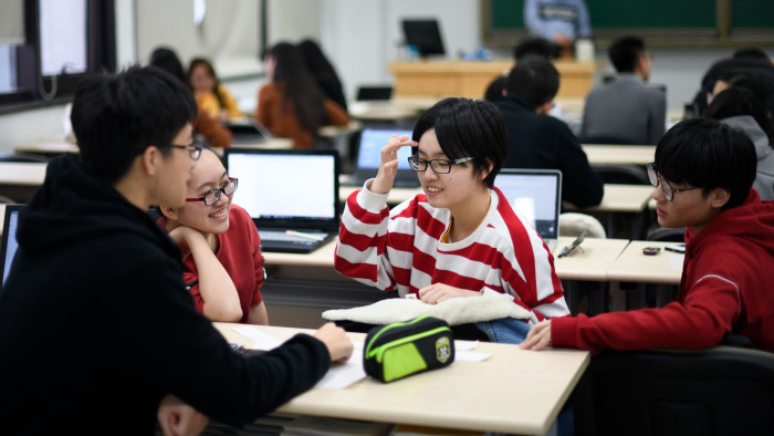 This picture taken on November 27, 2018 shows students talking in class at the Renmin business school in Renmin University, which claims to be the first Chinese university to offer a master's in business administration, in Beijing. - China's Communist Party has adapted market economics to its own system since enacting major reforms in 1978, paving the way for the rise of a multitude of companies -- and creating the need for business schools to train a new class of entrepreneurs. (Photo by WANG Zhao / AFP) / TO GO WITH China-politics-history-education, FOCUS by Elizabeth LAW (Photo credit should read WANG ZHAO/AFP via Getty Images)