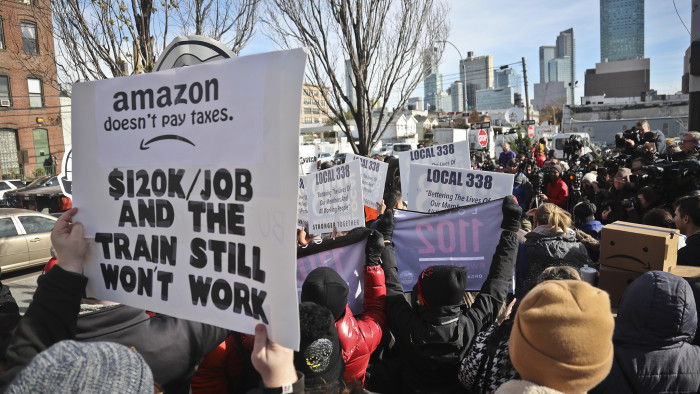 FILE- In this Nov. 14, 2018, file photo protesters carry anti-Amazon posters during a coalition rally and press conference opposing Amazon headquarters getting subsidies to locate in the New York neighborhood of Long Island City, Queens in New York. Amazon said Thursday, Feb. 14, 2019, that it will not be building a new headquarters in New York, a stunning reversal after a yearlong search. (AP Photo/Bebeto Matthews, File)