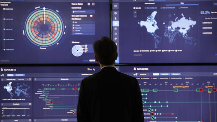 An employee looks at data on screens in the high-tech command center at the Novartis AG campus in Basel, Switzerland, on Wednesday, Jan. 16, 2019. Trying to streamline an operation that spends more than $5 billion a year on developing new drugs, Novartis dispatched teams to jetmaker Boeing Co. and Swissgrid AG, a power company, to observe how they use technology-laden crisis centers to prevent failures and blackouts. Photographer: Stefan Wermuth/Bloomberg