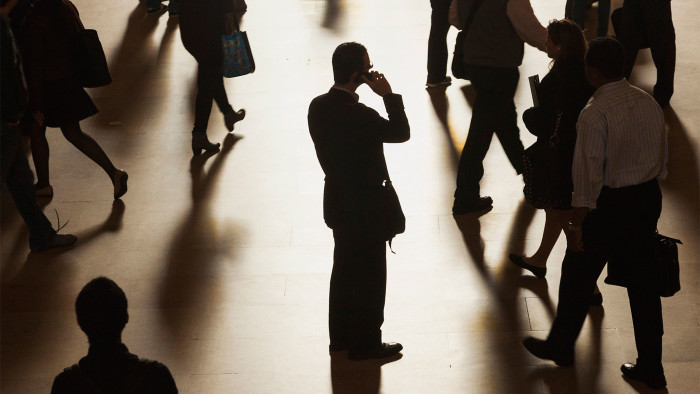 A man stands in the middle of Grand Central Terminal as he speaks on a cell phone