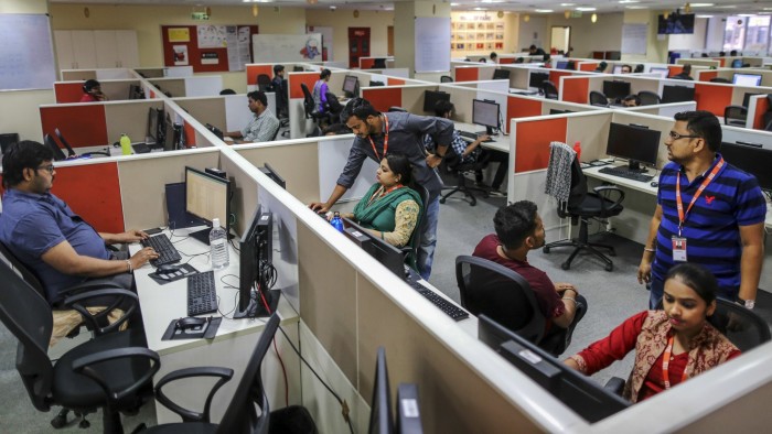 Employees work at a call center servicing Xiaomi Corp. in Bengaluru, India, on Friday, March 31, 2017. Once compared with Apple Inc. for its sleek smartphones and charismatic leadership, Chinese startup Xiaomi is seeking an image makeover as it tries to recover from a sales-growth slide. Photographer: Dhiraj Singh/Bloomberg