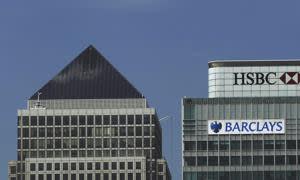 Offices for HSBC and Barclays banks stand next to the One Canada Square skyscraper, at left, in the Canary Wharf business district of London, Monday, April 11, 2011. A British commission recommended Monday that banks should be reorganized so that firewalls protect retail operations from investment banking, an attempt to shield taxpayers from the sector's risk-taking without forcing the banks to split up. (AP Photo/Matt Dunham)