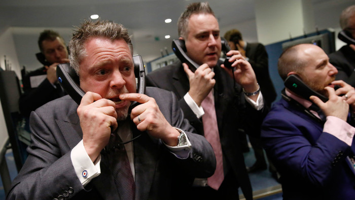 Traders, clerks and brokers speak on telephones on the trading floor of the open outcry pit at the London Metal Exchange (LME), on the last day of trading at their Leadenhall Street premises, in London, U.K., on Wednesday, Jan. 27, 2016. Photographer: Luke MacGregor/Bloomberg