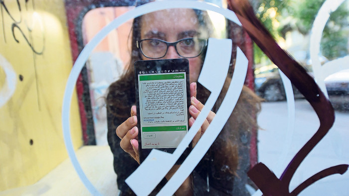 Showing her phone with an app on it, Nina Tov, one of the Hungarian brainchilds behind the InfoAid smartphone app, a multilingual tool (in Arabic, Farsi, Pashtu, Urdu, and English) to help migrants get accurate up-to-date information about everything from train timetables to asylum regulations to how to find missing relatives on September 14, 2015