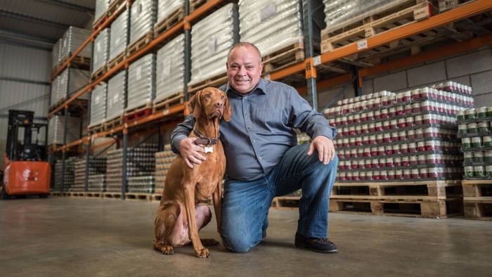 Eddie Milbourne of Symply pet food. Photographed in his warehouse with Hungarian Vizsla Frankie.