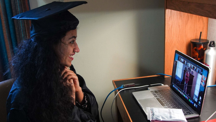 Pakistani student Varsha Thebo, 27, attends her online graduation ceremony in her bedroom at the International Student House where she resides at Georgetown University, in Washington, DC on May 15, 2020. - Varsha studied Global Human Development, her graduation ceremony was cancelled due to the coronavirus pandemic, so she is celebrating online instead. (Photo by Agnes BUN / AFP) (Photo by AGNES BUN/AFP via Getty Images)