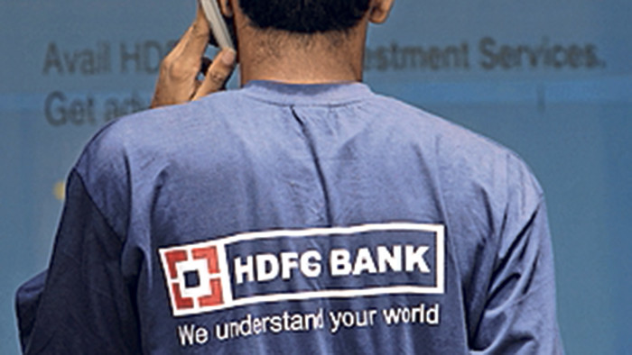 An employee of HDFC Bank Ltd., talks on his mobile phone outside a bank branch in Mumbai, India, on Tuesday, July 10, 2007