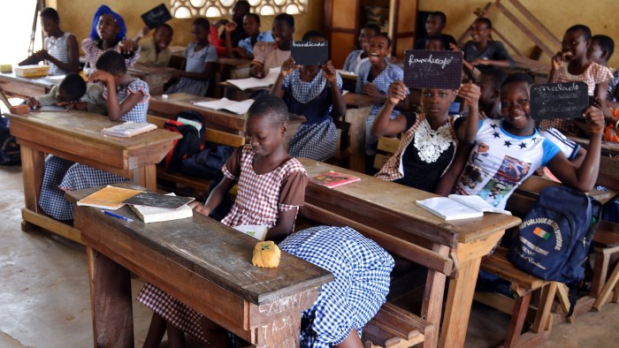 TO GO WITH AFPS TORY BY ADAMA BAKAYOKO 
Aicha, an 11-year old school girl, sinks behind her desk as journalists come to see her in her class in the central city of Bouake, Ivory Coast, on October 23, 2014. On October 29, a court will rule whether he spends the next year in prison, a sentence the prosecutor called &quot;lenient&quot; but an unprecedented signal to stop the impunity child marriage now enjoys in this west African state where it is illegal -- but widespread.  AFP PHOTO / ISSOUF SANOGO        (Photo credit should read ISSOUF SANOGO/AFP/Getty Images)