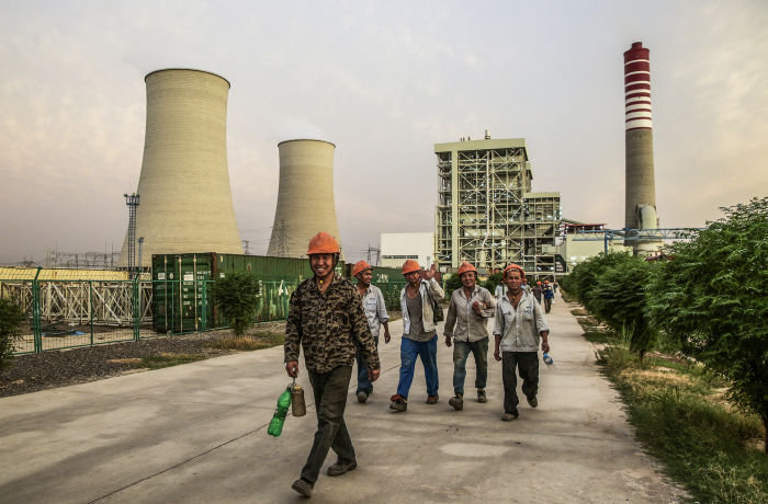 Chinese workers walk along a path at the Sahiwal coal power plant, owned by China's state-owned Huaneng Shandong Rui Group, in Sahiwal, Punjab, Pakistan, on Wednesday, June 14, 2017. Pakistan is racing to bridge its power supply gap before national elections next year after a series of widespread blackouts highlighted the fragility of the network and its negative pull on South Asia’s second largest economy. Photographer: Asad Zaidi/Bloomberg