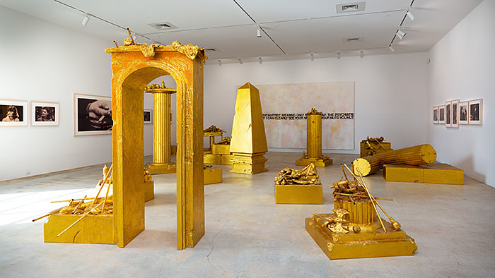 The Rubells photographed for The FT by Melanie Metz at the Rubell Museum, Miami. For the second image: (gold sculptural installation throughout the space): John Miller, A Refusal to Accept Limits, 2007 (left wall, front to back): Richard Prince, Untitled (three women looking in the same direction), 1980 Richard Prince, Untitled (man’s hand with cigarette), 1980 Richard Prince, Untitled (Living Rooms), 1977 (back wall): Richard Prince, Nuts, 2000 (right wall, 6 different works, each): Richard Prince, Untitled (cowboy), 1987