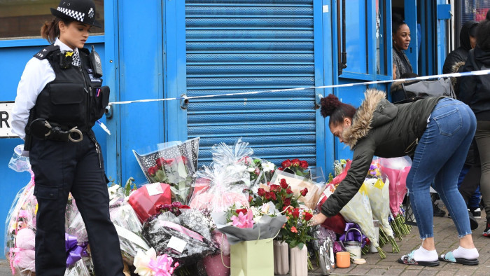 A woman lays flowers on Chalgrove Road, Tottenham, north London, where a 17-year-old girl has died after she was shot Monday evening. PRESS ASSOCIATION Photo. Picture date: Tuesday April 3, 2018. Later, police in nearby Walthamstow found two young victims suffering from gun shot and knife wounds. See PA story POLICE Tottenham. Photo credit should read: Victoria Jones/PA Wire