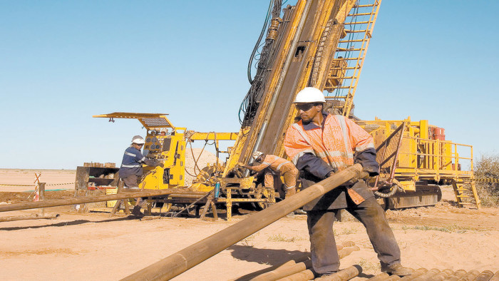 DEGPDB Rig operator pulling out core tube and making a new connection on RC diamond drill exploration rig, surface gold mine Mauritania