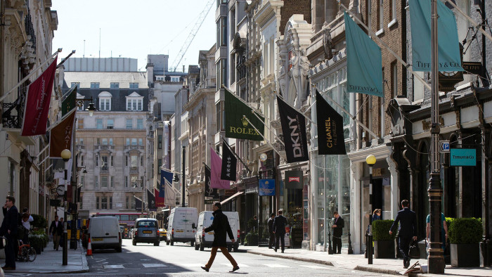 Members of the public walk past luxury goods retailers on Old Bond Street on April 15, 2014 in London, England