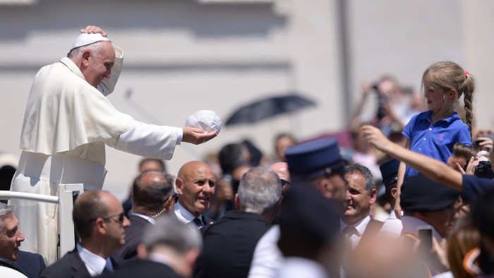 The Pope exchanges his skull cap with a girl during his weekly audience in St Peter's square on Wednesday