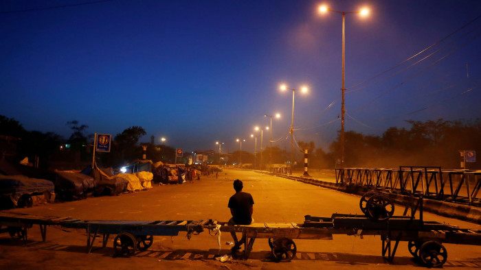 A man sits on a handcart erected across a road, as a blockade, during an extended nationwide lockdown to slow the spreading of the coronavirus disease (COVID-19), in New Delhi, India, April 15, 2020. REUTERS/Adnan Abidi TPX IMAGES OF THE DAY