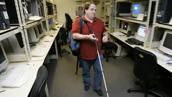 Microsoft Corp. employee Kelly Ford, a test lead for the Internet Explorer internet browser user experience, walks Monday, Sept. 25, 2006 through the lab in Redmond, Wash. used to test various accessibility features of the Windows operating system as well as third-party accessibility products designed to work with Windows. Ford, who has been blind since birth, was testing a program Monday that provides audible feedback about what is being displayed on a web page and also displays web-page information on a &quot;braille display&quot; that can be read by touch. As part of his job, Ford also manages a team of people who are working to improve web page browsing for all users, not just those with disabilities. (AP Photo/Ted S. Warren)