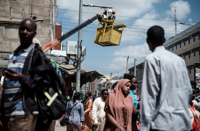 A worker cleans a surveillance camera on a street in Nairobi, on January 18, 2019. (Photo by Yasuyoshi CHIBA / AFP) (Photo credit should read YASUYOSHI CHIBA/AFP via Getty Images)