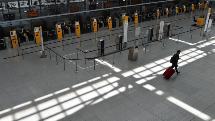 TOPSHOT - A passenger walks in an empty Lufthansa terminal at the "Franz-Josef-Strauss" airport in Munich, southern Germany, on May 27, 2020. - Coronavirus-stricken airline group Lufthansa wavered on May 27, 2020 on grabbing a nine-billion-euro ($9.9 billion) German state lifeline, throwing up new turbulence for a rescue that could decide the fate of the historic company. (Photo by Christof STACHE / AFP) (Photo by CHRISTOF STACHE/AFP via Getty Images)