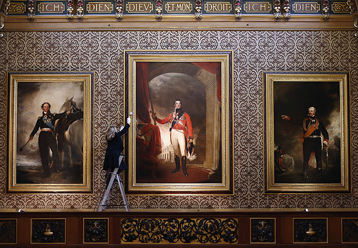 Press preview for Waterloo at Windsor: 1815-2015 Exhibition...WINDSOR, ENGLAND - JANUARY 28: A member of the Royal Collection staff poses besides a portrait of the Duke of Wellington in the Waterloo Chamber during a press preview for Waterloo at Windsor: 1815-2015 Exhibition at Windsor Castle on January 28, 2015 in Windsor, England. Paintings in the chamber will be on display with objects presented to George IV from the battle of Waterloo, which celebrates it's bicentennial this year. The exhibition opens at Windsor Castle from January 31, to January 13, 2016 as part of the 200th anniversary of the Battle of Waterloo celebrations. (Photo by Dan Kitwood/Getty Images)