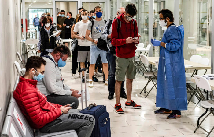 A health worker checks the medical documents of travellers arriving at Cyprus' Larnaca International Airport on June 9, 2020, before being screened for COVID-19 coronavirus symptoms on their way to passport control. - Cyprus opened back up for international tourism on June 9, with airports welcoming visitors after an almost three-month shutdown due to the novel coronavirus pandemic, with a bold plan to cover health care costs for visitors. (Photo by Iakovos Hatzistavrou / AFP) (Photo by IAKOVOS HATZISTAVROU/AFP via Getty Images)