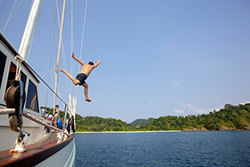 A man jumps off the Meta IV yacth and into the waters of the Mergui archipelago