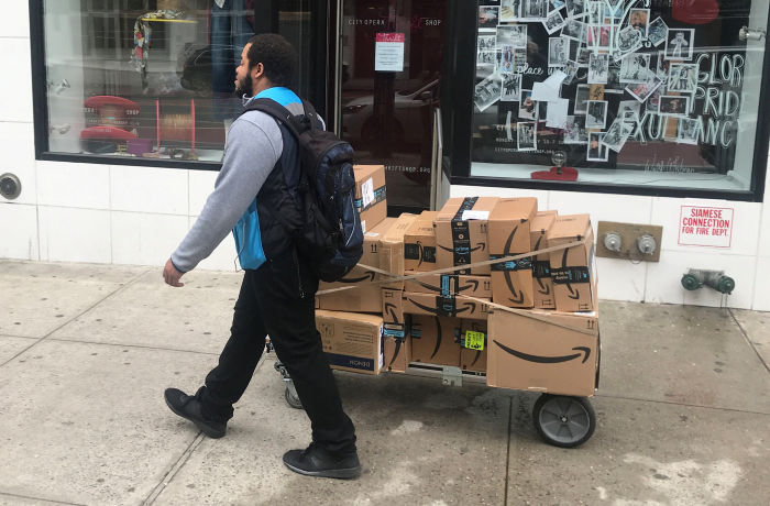 A man delivers Amazon packages following the spread of Coronavirus disease (COVID-19), in the Manhattan borough of New York City, New York, U.S., March 20, 2020. REUTERS/Carlo Allegri