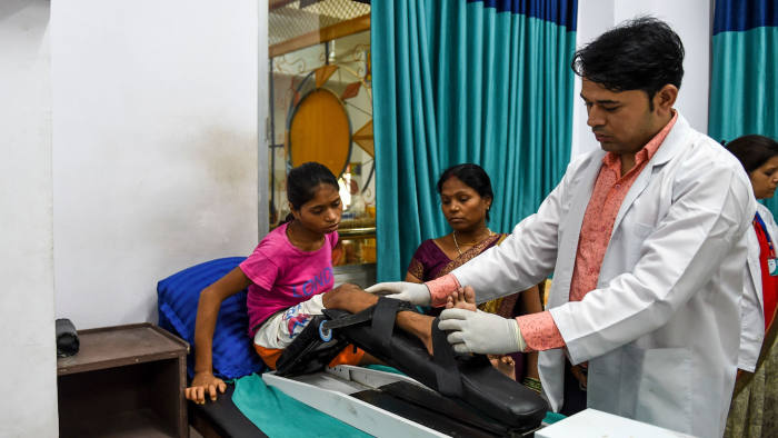 In this photograph taken on September 7, 2019, a doctor treats a differently-abled girl at 'Narayan Seva Sansthan', a Non-Governmental Organisation (NGO) for differently-abled people, on the outskirts of Udaipur in Rajasthan state. - Founded by Kailash Agarwal Manav, recipient of 'Padma Shree Award', the 'Narayan Seva Sansthan' NGO aims at empowering differently-abled and underprivileged people through donations at 480 branches located in India and 86 abroad. (Photo by SAM PANTHAKY / AFP) (Photo credit should read SAM PANTHAKY/AFP/Getty Images)