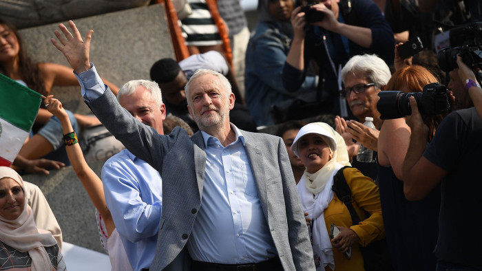LONDON, ENGLAND - JULY 13: Labour Party leader Jeremy Corbyn waves as he visits Trafalgar Square at a demonstration against President Trump's visit to the UK on July 13, 2018 in London, England. Tens of Thousands Of Anti-Trump protesters are expected to demonstrate in London and across the country against the UK visit by the President of the United States. Many people disagree with his policies that include migrant family separation, discrimination of transgender military personnel and changes to laws protecting women's sexual health. (Photo by Chris J Ratcliffe/Getty Images)