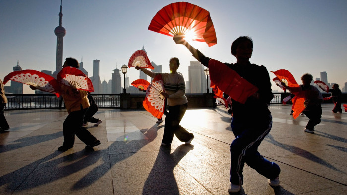 C3X46M China. Shanghai. The Bund. Background: Skyline of Pudong (Business District) Doing morning exercises (Tai Chi).
