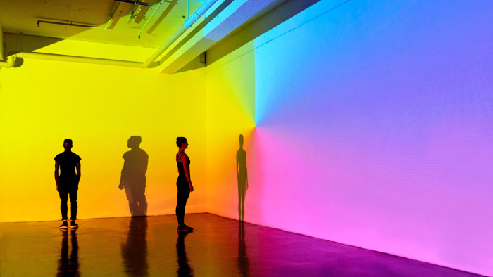 man and woman standing in a gallery space with colourful walls