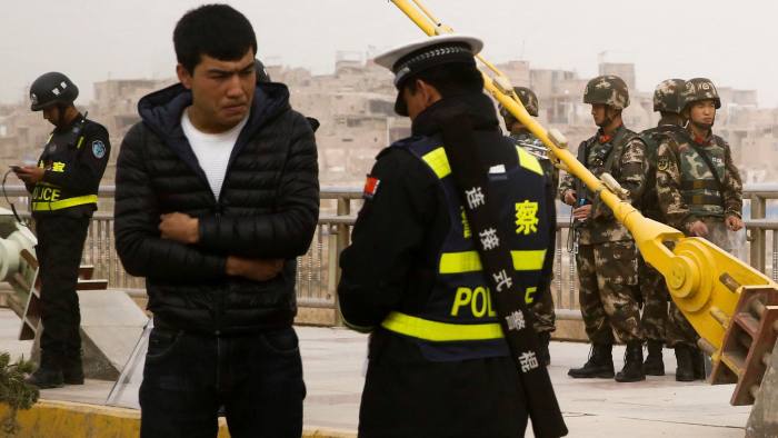 A police officer checks the identity card of a man as security forces keep watch in a street in Kashgar, Xinjiang Uighur Autonomous Region, China, March 24, 2017. REUTERS/Thomas Peter SEARCH "XINJIANG PETER" FOR THIS STORY. SEARCH "WIDER IMAGE" FOR ALL STORIES.